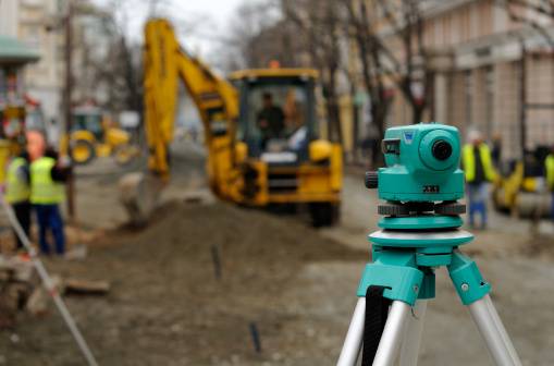 Teodolito y excavadora en obra de Comasa Norte